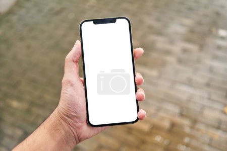 Foto de Hombre sosteniendo teléfono inteligente que muestra la pantalla en blanco blanco en la calle - Imagen libre de derechos