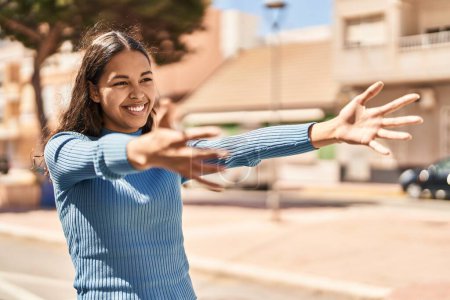 Téléchargez les photos : Young african american woman smiling confident doing hug gesture at street - en image libre de droit