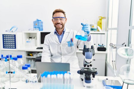 Photo for Middle age hispanic man wearing scientist uniform working at laboratory - Royalty Free Image