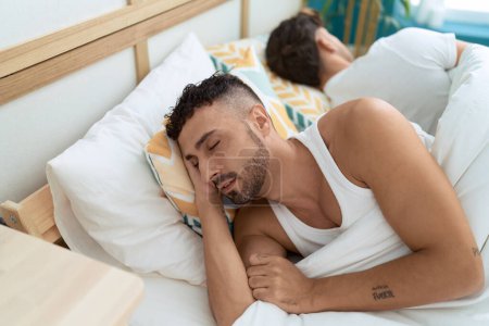 Téléchargez les photos : Two hispanic men couple lying on bed sleeping at bedroom - en image libre de droit