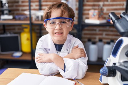 Photo for Adorable hispanic boy student smiling confident standing with arms crossed gesture at laboratory classroom - Royalty Free Image