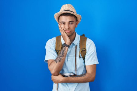 Photo for Brazilian young man holding vintage camera thinking looking tired and bored with depression problems with crossed arms. - Royalty Free Image
