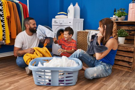 Photo for Family smiling confident playing with clothes at laundry room - Royalty Free Image