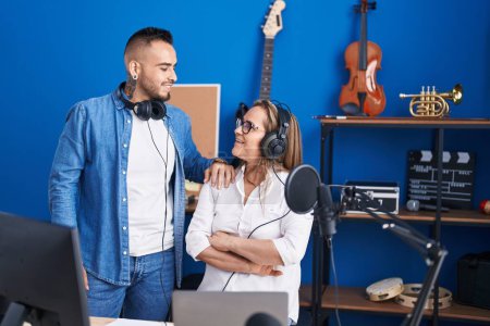 Téléchargez les photos : Musiciens hommes et femmes écoutant de la musique les bras croisés au studio de musique - en image libre de droit