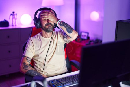 Téléchargez les photos : Jeune homme chauve streamer souligné en utilisant l'ordinateur à la salle de jeux - en image libre de droit