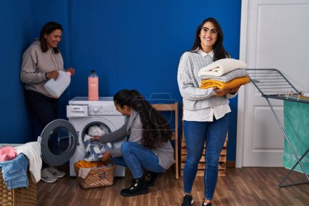 Photo for Three woman washing clothes at laundry room - Royalty Free Image