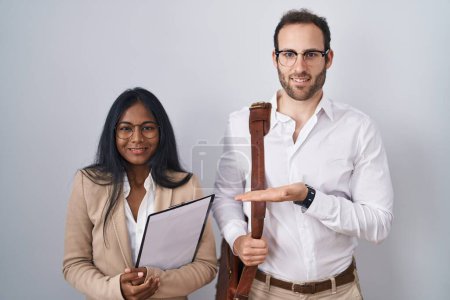 Photo for Interracial business couple wearing glasses pointing aside with hands open palms showing copy space, presenting advertisement smiling excited happy - Royalty Free Image
