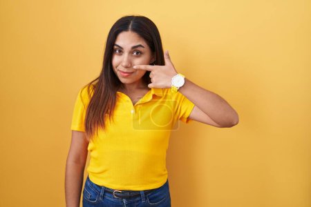 Téléchargez les photos : Young arab woman standing over yellow background pointing with hand finger to face and nose, smiling cheerful. beauty concept - en image libre de droit