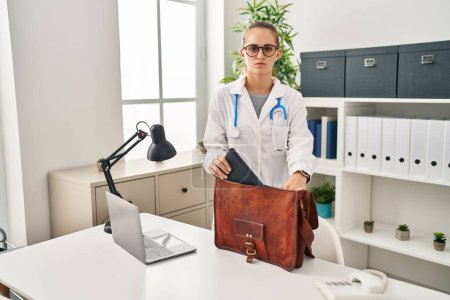 Photo for Young doctor woman at the clinic depressed and worry for distress, crying angry and afraid. sad expression. - Royalty Free Image