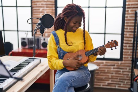Téléchargez les photos : Femme musicienne afro-américaine jouant de l'ukulélé au studio de musique - en image libre de droit