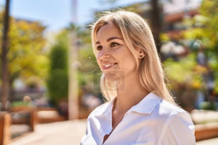 Photo for Young blonde woman smiling confident standing at park - Royalty Free Image