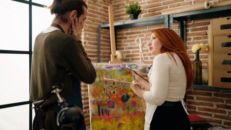 Téléchargez les photos : Homme et femme couple regardant dessin parlant au studio d'art - en image libre de droit