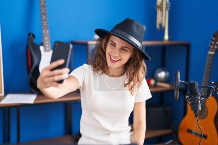 Photo for Young woman musician making selfie by smartphone at music studio - Royalty Free Image