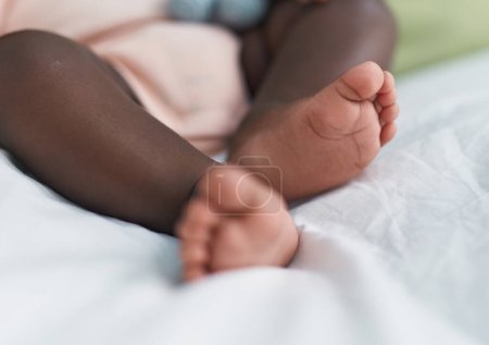 Téléchargez les photos : African american baby lying on bed at bedroom - en image libre de droit