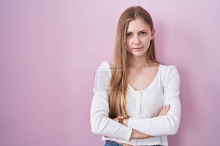 Téléchargez les photos : Young caucasian woman standing over pink background skeptic and nervous, disapproving expression on face with crossed arms. negative person. - en image libre de droit