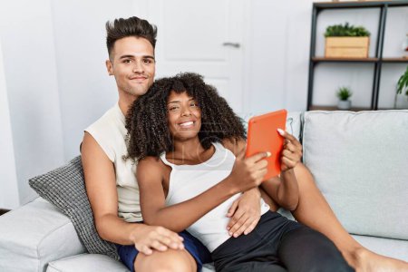 Foto de Hombre y mujer pareja usando touchpad abrazándose en casa - Imagen libre de derechos