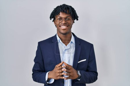 Téléchargez les photos : Young african man with dreadlocks wearing business jacket over white background hands together and fingers crossed smiling relaxed and cheerful. success and optimistic - en image libre de droit