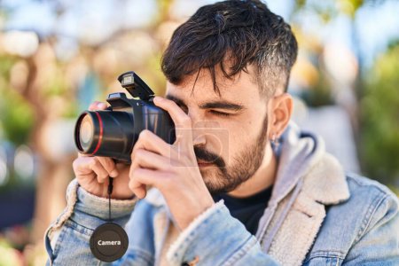 Téléchargez les photos : Young hispanic man using professional camera at park - en image libre de droit