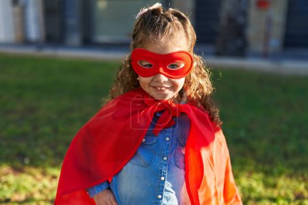 Foto de Adorable rubio niño sonriendo confiado usando superhéroe personalizado en el parque - Imagen libre de derechos
