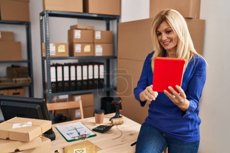 Foto de Mujer rubia de mediana edad trabajadora de negocios usando touchpad en la oficina - Imagen libre de derechos