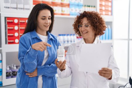 Téléchargez les photos : Deux femmes pharmacien et client prescrivent des pilules à la pharmacie - en image libre de droit
