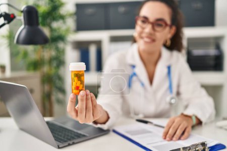 Téléchargez les photos : Young beautiful hispanic woman doctor prescribe pills treatment at clinic - en image libre de droit