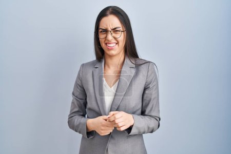 Photo for Hispanic business woman wearing glasses disgusted expression, displeased and fearful doing disgust face because aversion reaction. with hands raised - Royalty Free Image