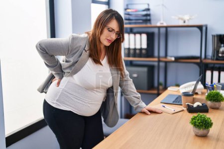 Téléchargez les photos : Jeune femme enceinte travailleur d'affaires souffrant de maux de dos au bureau - en image libre de droit