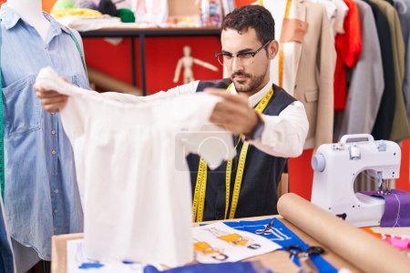Photo for Young hispanic man tailor holding t shirt at atelier - Royalty Free Image