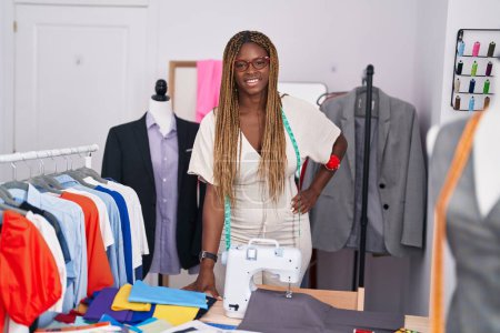 Téléchargez les photos : Femme afro-américaine tailleur souriant confiance debout au magasin de tailleur - en image libre de droit