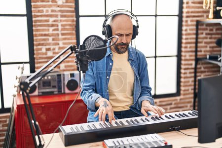 Téléchargez les photos : Young bald man musician playing piano at music studio - en image libre de droit