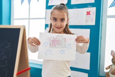 Téléchargez les photos : Adorable hispanic girl preschool student holding draw at kindergarten - en image libre de droit