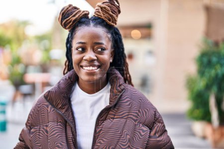 Téléchargez les photos : Afro-américaine femme souriant confiant regardant vers le côté à la rue - en image libre de droit