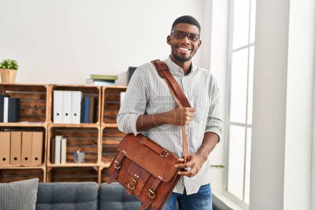 Photo for Young african american man psychologist holding briefcase at clinic - Royalty Free Image