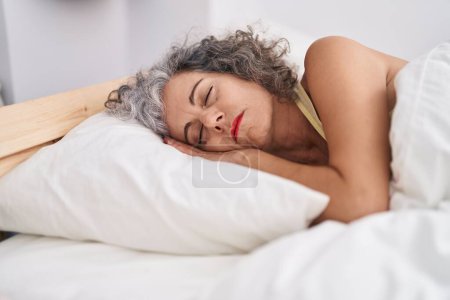 Foto de Mujer de pelo gris de mediana edad acostada en la cama durmiendo en el dormitorio - Imagen libre de derechos