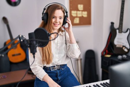 Photo for Young caucasian woman recording song at music studio looking positive and happy standing and smiling with a confident smile showing teeth - Royalty Free Image