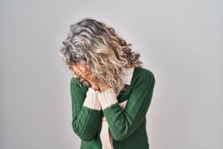 Téléchargez les photos : Middle age woman standing over white background with sad expression covering face with hands while crying. depression concept. - en image libre de droit