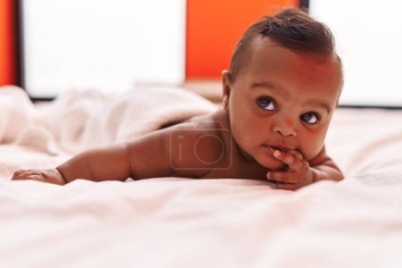 Photo for African american baby lying on bed at bedroom - Royalty Free Image