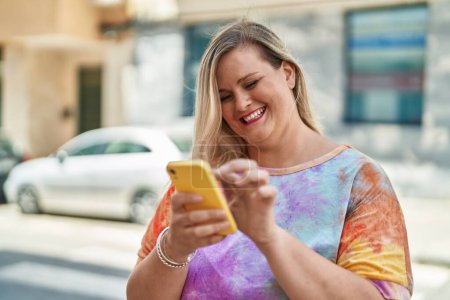 Téléchargez les photos : Jeune femme souriant confiant en utilisant smartphone à la rue - en image libre de droit