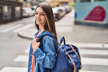 Adorable girl student smiling confident wearing backpack at street