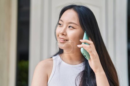 Téléchargez les photos : Young chinese woman smiling confident talking on the smartphone at street - en image libre de droit