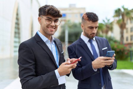 Photo for Two hispanic men business workers smiling confident using smartphones at street - Royalty Free Image