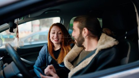 Foto de Hombre y mujer pareja usando teléfono inteligente sentado en el coche en la calle - Imagen libre de derechos