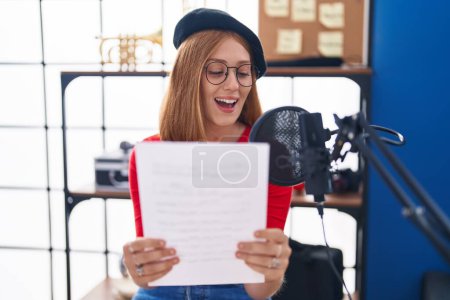 Téléchargez les photos : Young redhead woman artist singing song at music studio - en image libre de droit