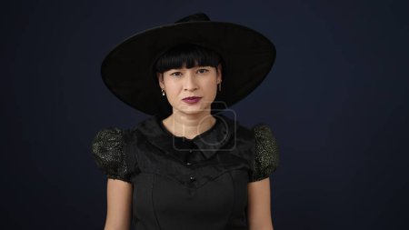 Photo for Young chinese woman wearing witch costume having halloween party over isolated black background - Royalty Free Image