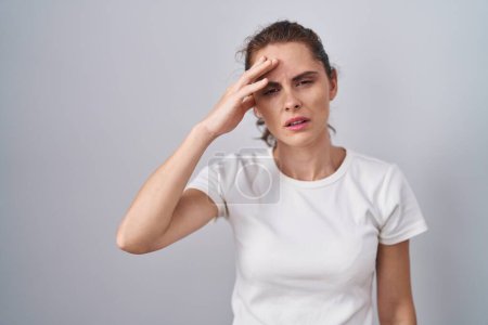 Photo for Beautiful brunette woman standing over isolated background pointing unhappy to pimple on forehead, ugly infection of blackhead. acne and skin problem - Royalty Free Image