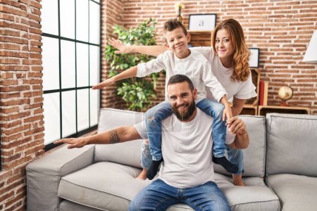 Photo for Family smiling confident playing sitting on sofa at home - Royalty Free Image