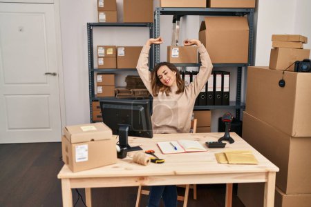 Foto de Mujer joven comercio electrónico trabajador de negocios estirar los brazos en la oficina - Imagen libre de derechos
