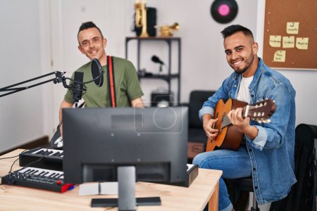 Téléchargez les photos : Deux musiciens hommes jouant de la guitare classique et électrique au studio de musique - en image libre de droit