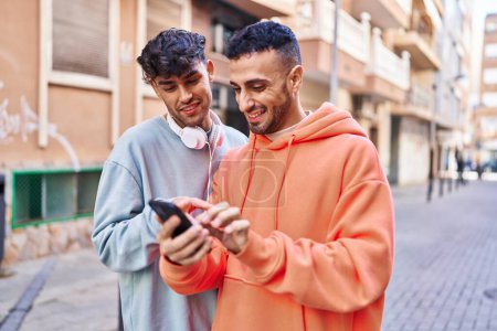 Foto de Dos hombre pareja usando teléfono inteligente en la calle - Imagen libre de derechos